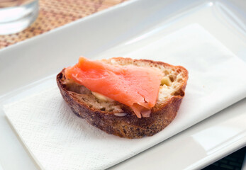 delicious canapes of salted smoked salmon fillet on a slice of fresh bread