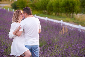 Fototapeta premium Young couple in love bride and groom, wedding day in summer. Enjoy a moment of happiness and love in a lavender field.