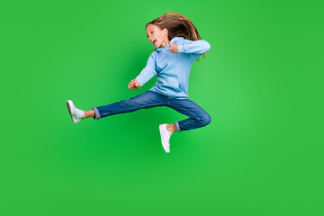 Fototapeta na wymiar Full body photo of energetic small girl jump practicing martial arts fan dressed trendy blue sportswear isolated on green color background