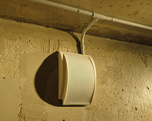Emergency fire exit speaker for sound siren alarm on textured wall. Safety equipment in residential...