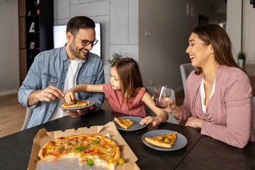 Portrait of happy family sharing pizza at home