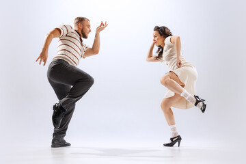 Rhythm and expression. Energetic dance couple in retro style outfits dancing lindy hop, jive...