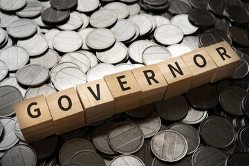 知事・長官・理事のイメージ｜「GOVERNOR」と書かれたブロックとコイン
