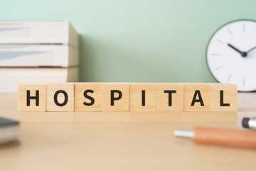 病院のイメージ｜「HOSPITAL」と書かれたブロックが置かれたデスク
