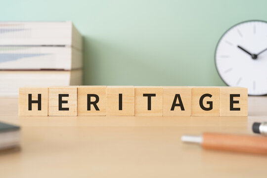 遺産・相続・伝統のイメージ｜「HERITAGE」と書かれたブロックが置かれたデスク
