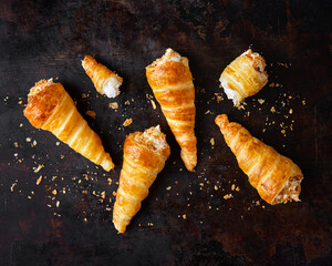 Puff pastry horns filled with Italian meringue, Schaumrollen o Cream Horns on dark background, copy space, top view, flat lay, no people.