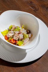 Salad with fish meat, parsley, tomatoes and olives