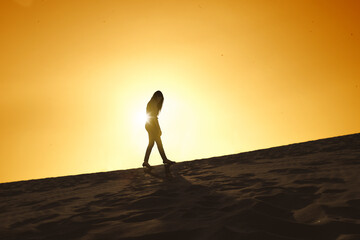 Silhouette of sad businesswoman walking on desert