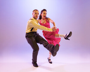 Emotional bright couple of dancers in colorful retro style attires dancing incendiary dances...