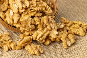 Basket with peeled walnuts on burlap.
