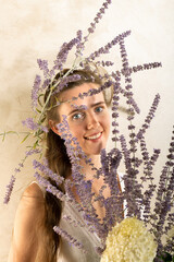 Blick durch russischen Lavendel, junge Frau blickt durch einen Strauß von Blauraute.