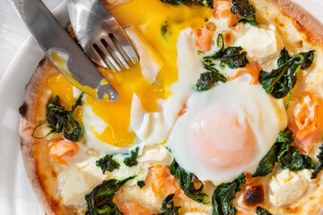 Pizza with fried egg, shrimps, cheese and spinach