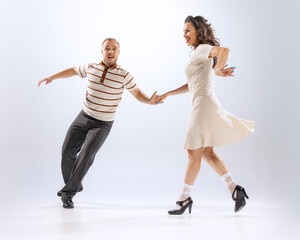 Naklejka premium Astonished young dancing man and woman dance sport dances isolated on white background. 50s, 60s ,70s american fashion style.