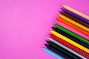 Color pencils on pink background, copy space .
