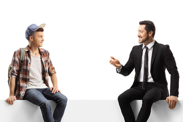 Businessman talking to a male student seated on a blank panel