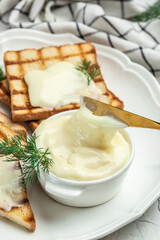 cream cheese and butter for breakfast. melted cheese on light background. vertical image. place for text