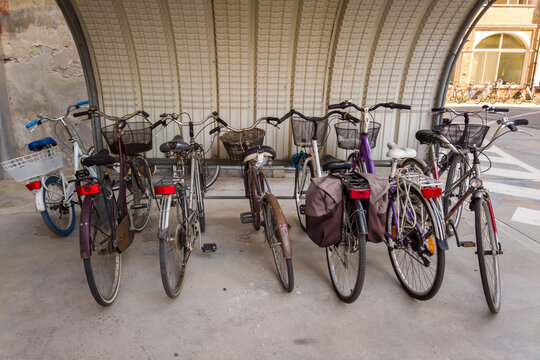 Bicycles parked under the canopy, bike with basket and bags