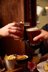 Man and woman drink lager beer and stout. Friends having alcoholic drinks in the bar