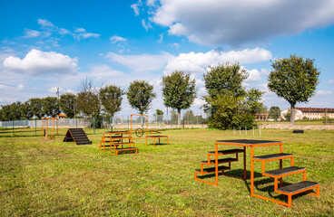 Area equipped for dog training. Dog training in a fenced area..Obstacle courses with tunnels, steep ramp, slides, poles and high jump.
