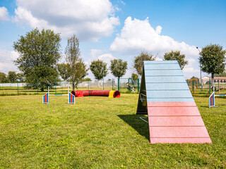 Area equipped for dog training. Dog training in a fenced area..Obstacle courses with tunnels, steep ramp, slides, poles and high jump.