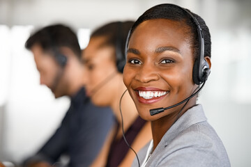 Black mature customer service woman on call with big smile