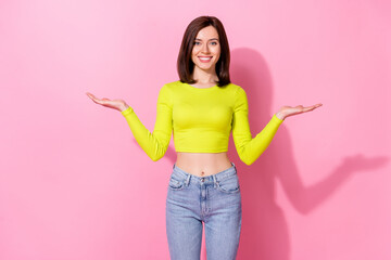 Photo of shiny sweet girl dressed lime shirt comparing arms empty space isolated pink color...