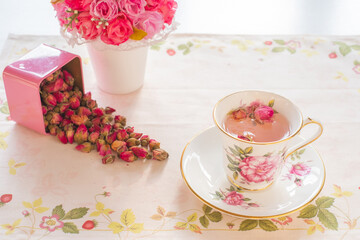 Cup of roses tea with rose buds in pink box and vase with roses,vintage tone, Afternoon tea party concept