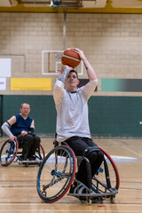 Male basketball player in wheelchair shooting ball