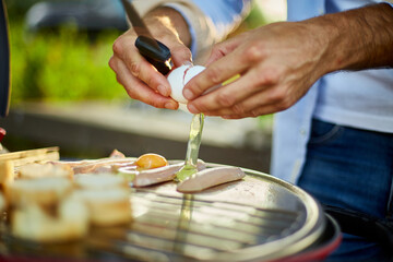 Close up on man's hand break eggs, roasting bruschetta and sausages