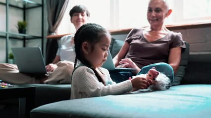 Pretty mature lesbian couple working on laptop and talking with adopted Asian daughter at home