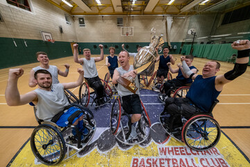 Team of basketball players in wheelchairs celebrating with trophy - obrazy, fototapety, plakaty