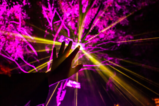 Rays of light from festival display shine through mans hand