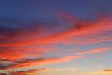 日の出が雲に映り込む朝焼けの空