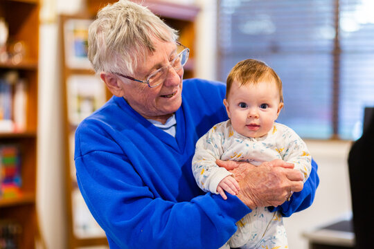Happy great grandmother holding baby great grandchild