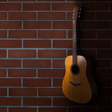 brown acoustic guitar stand in front of brick wall background. Guitar body part front made with top solid, side and back mahogany wood. © chaiwat