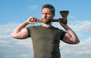 confident man with axe. lumberjack man hold ax. brutal man on sky background