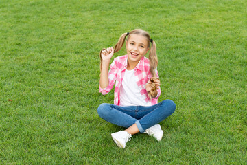 glad teen child sit on green grass outdoor