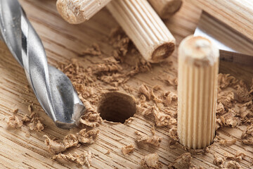 drill bit makes hole in wooden oak board for wooden dowel.