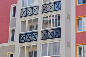 The stylish facade of a residential building with beautiful windows is a new multi-apartment residential quarter of European houses.