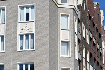 The stylish facade of a residential building with beautiful windows is a new multi-apartment residential quarter of European houses.