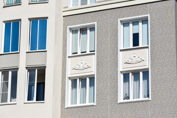 Stylish facade of a residential building with beautiful windows. Quarter of European houses. Abstraction in the city