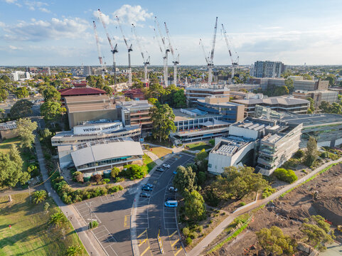 Aerial view of a large University campus with large construction cranes above