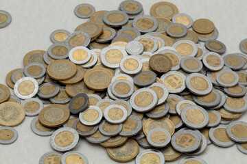 bunch of Mexican pesos coins of various denominations, with copy space