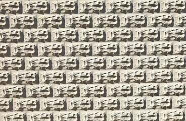Gray concrete wall with decorative rectangle forms in shape of rocks carved on the surface. Background and texture.