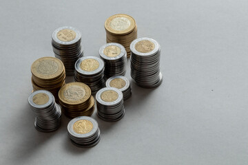 Mexican pesos of different denominations with side lighting, on a table with copy space