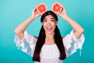 Fototapeta Photo of sweet dreamy girl dressed off shoulders blouse looking up empty space rising head citrus slices isolated teal color background obraz