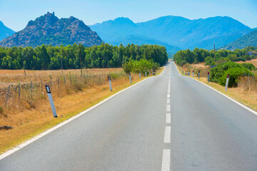 Country asphalt road in Europe. Travel landscape with mountains on horizon
