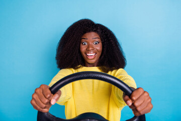 Closeup photo of young driving woman holding car steering wheel shocked high speed isolated on blue...