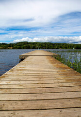 Empty pier on the lake shore, wooden long dock as a peaceful scenery and wallpaper concept image.