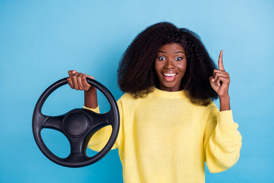 Photo of pretty lovely funny girl curly hairdo wear yellow jumper directing empty space astonished isolated on blue color background